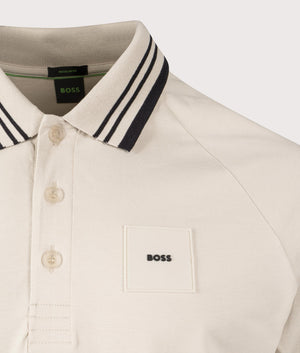 BOSS Paddy Rib Polo Shirt in Open Beige. Shot at EQVVS. Front logo shot