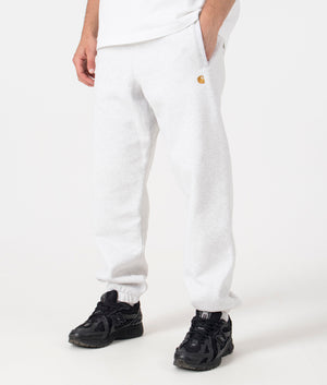 Carhartt WIP Relaxed Fit Chase Joggers in Ash Heather/Gold. Side angle model shot at EQVVS.