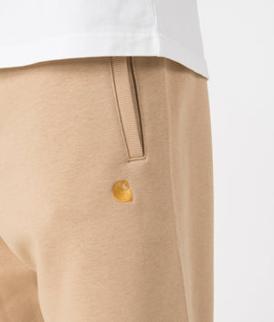 Carhartt WIP Relaxed Fit Chase Joggers in Sable/Gold. Detail angle model shot at EQVVS.