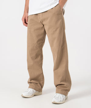 Carhartt WIP Relaxed Fit Floyde Pants in Leather. Side angle model shot at EQVVS.