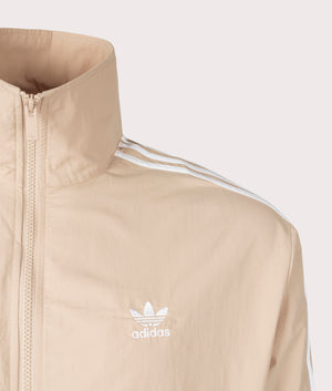 The adidas Originals Firebird Track Top in Magic Beige. Detail angle shot at EQVVS.