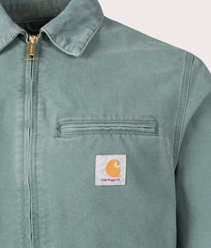 Carhartt WIP Detroit Jacket in Silver Pine, 100% Cotton at EQVVS. Detailed logo shot. 