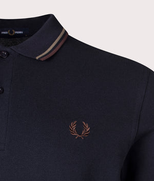 The Twin Tipped Fred Perry Polo Shirt in Navy/Laurel Wreath Green/Carrington Road Brick. Detail angle shot at EQVVS.