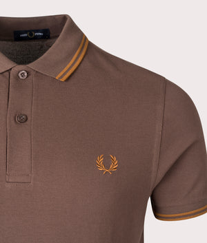 Fred Perry twin-tipped polo in Carrington Road Brick, 100% Cotton at EQVVS. Detaield logo shot. 