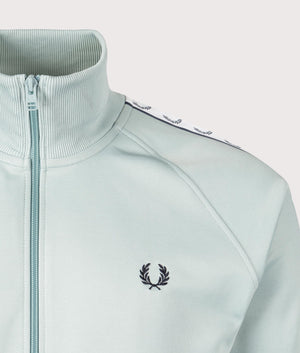 Fred Perry Taped Track Jacket in Silver Blue at EQVVS. Detailed logo shot. 