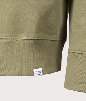 Norse Projects Relaxed Fit Ketel Quarter Zip Sweatshirt in Moss Green. Shot at EQVVS.  Detail shot. 