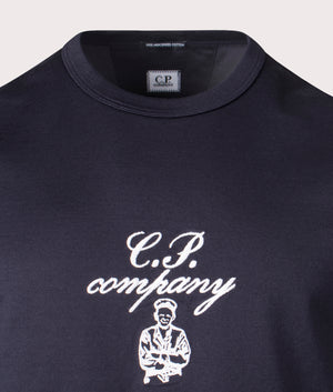 C.P. Company Twisted Embroidery T-Shirt in Total Eclipse, 100% Cotton Mercerised Jersey at EQVVS. Detailed logo shot. 