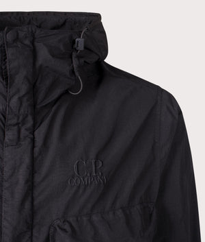 C.P. Company Flatt Nylon Goggle Jacket in black at EQVVS. Detailed logo shot. 