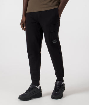 C.P. Company Diagonal Raised Lens Joggers in Black. Shot at EQVVS. Side angle shot. 