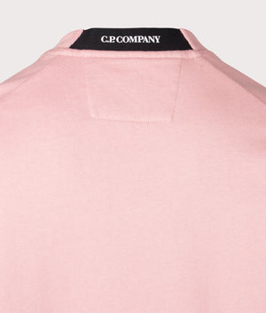 C.P. Company Diagonal Raised Lens Sweatshirt in Misty rose, 100% cotton at EQVVS. Detailed logo shot. 