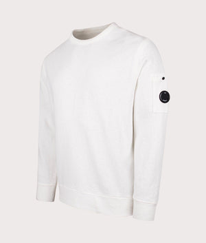 C.P. Company Lens Sleeve Crewneck Sweatshirt in Gauze White, 100% Cotton at EQVVS. Side shot. 