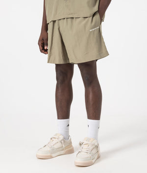 MKI Relaxed Fit Tencel Shorts in Sage Green. Side angle model shot at EQVVS.