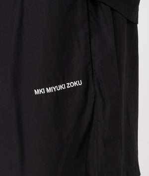 MKI Relaxed Fit Tencel Shorts in Black. Detail angle model shot at EQVVS.