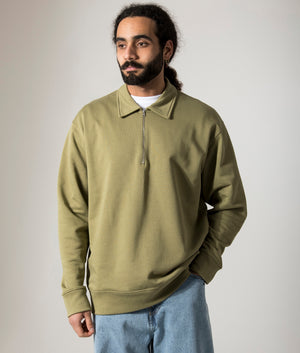 Norse Projects Relaxed Fit Ketel Quarter Zip Sweatshirt in Moss Green. Shot at EQVVS. Model Front shot. 