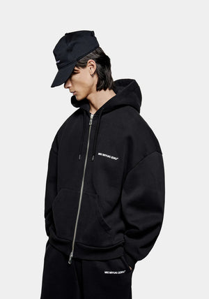 MKI Miyuki Zoku Uniform Zip Through Hoodie in Black. Shot at EQVVS.  Model shot. 
