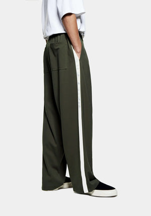 MKI Miyuki Zoku Olive Wide Fit Track Pants.  Model shot. 