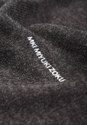 MKI MIYUKI ZOKU Mohair Blend Knit Hoodie in Charcoal at EQVVS Menswear. Logo Detail Shot. 